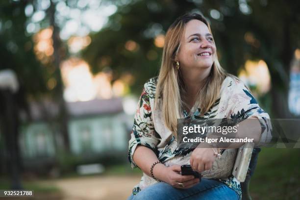 woman relaxing in public park - moving down to seated position stock pictures, royalty-free photos & images