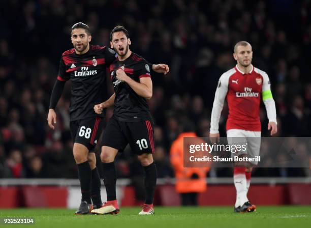 Hakan Calhanoglu of AC Milan clebrates the opening goal with Ricardo Rodriguez as Jack Wilshere of Arsenal looks on during the UEFA Europa League...