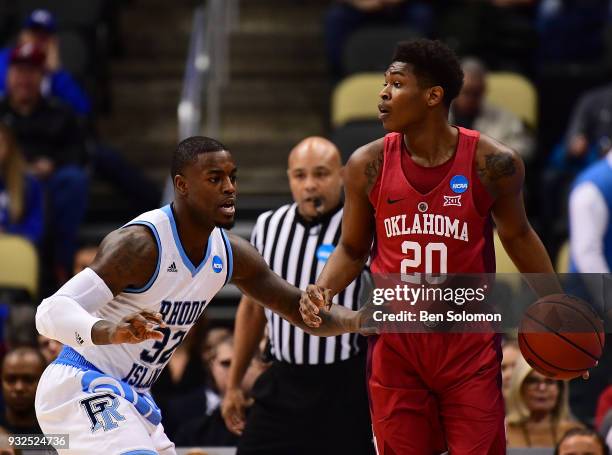 Kameron McGusty of the Oklahoma Sooners dribbles while being guarded by Jared Terrell of the Rhode Island Rams in the first half during the first...