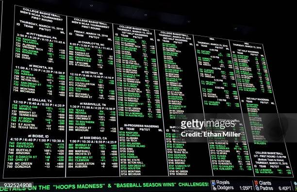 Betting lines for college basketball games are displayed during a viewing party for the NCAA Men's College Basketball Tournament inside the...