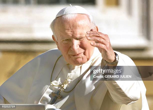 Pope John Paul II blesses a pilgrims from an open-top car on San Peter square in Vatican 14 October, following his regular weekly audience. Pope John...