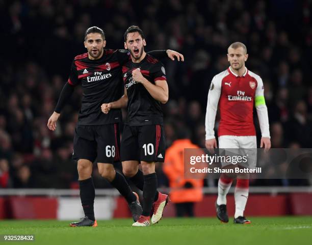 Hakan Calhanoglu of AC Milan clebrates the opening goal with Ricardo Rodriguez as Jack Wilshere of Arsenal looks on during the UEFA Europa League...