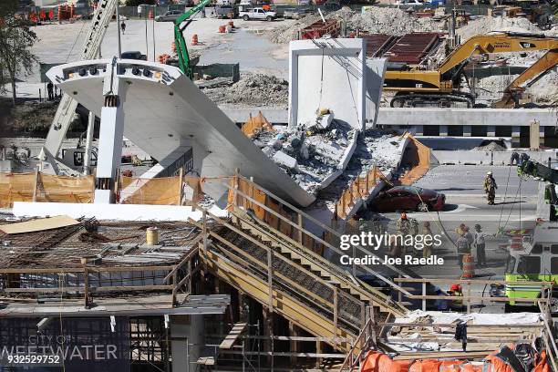 Miami-Dade Fire Rescue Department personel and other rescue units work at the scene where a pedestrian bridge collapsed a few days after it was built...