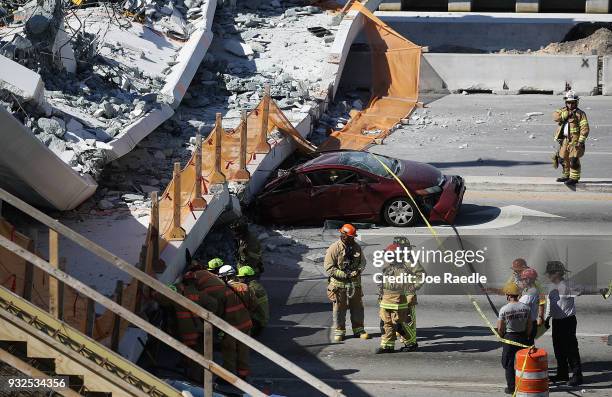 Miami-Dade Fire Rescue Department personel and other rescue units work at the scene where a pedestrian bridge collapsed a few days after it was built...