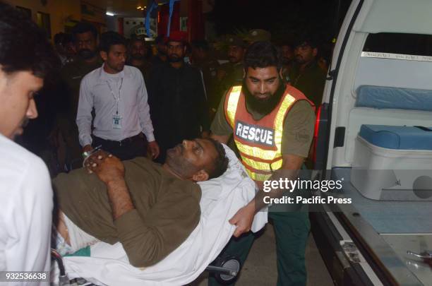 Pakistani rescue workers push a stretcher carrying an injured man to the hospital following the blast of a motorcycle bomb attack. Nine people were...