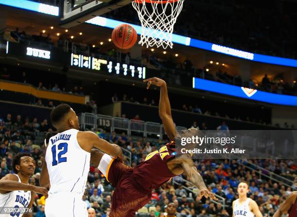 Rickey McGill of the Iona Gaels falls in front of Javin DeLaurier of the Duke Blue Devils during the first half of the game in the first round of the...