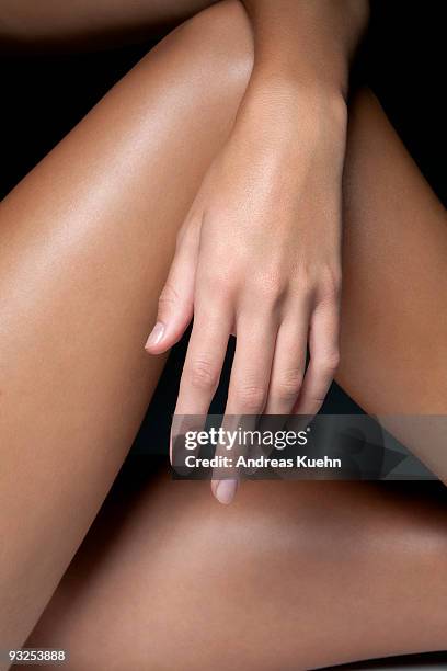 naked young woman's hand and legs, close up. - handschoen stock-fotos und bilder