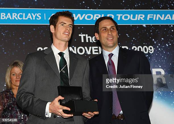 Andy Murray of Great Britain receives a trophy from the CEO of the ATP Adam Helfant during the Barclays ATP World Tour Finals - Media Day at the...