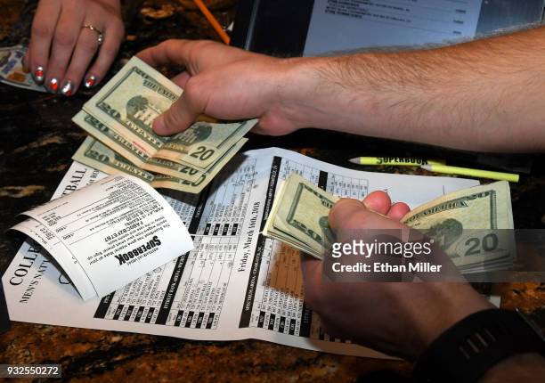Jake Sindberg of Wisconsin makes bets during a viewing party for the NCAA Men's College Basketball Tournament inside the 25,000-square-foot Race &...