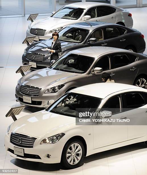 Employees for Japanese auto giant Nissan Motor prepare for a presentation of the company's new luxury sedan "Fuga", equipped with 2.5 or 3.7-litre V6...
