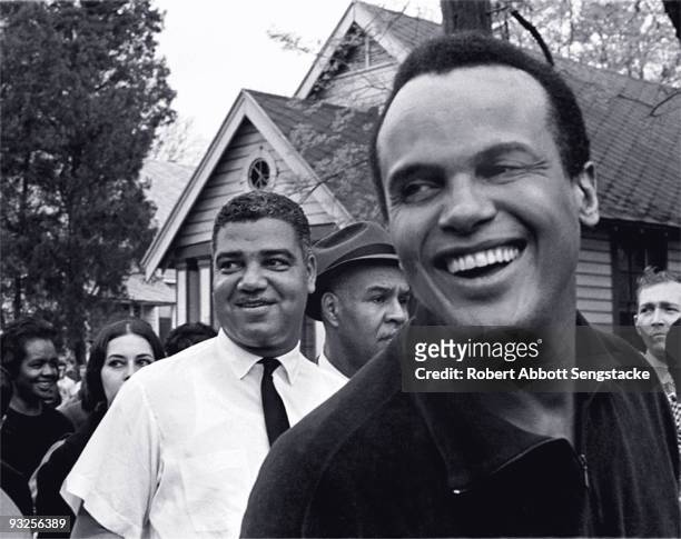 The actor and civil rights ativist Harry Belafonte smiles broadly while marching with National Urban League director Whitney Young and NAACP...