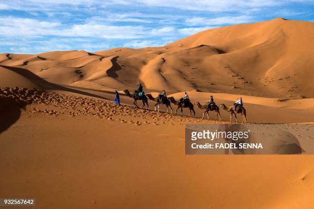 Riders compete during the "Gallops of Morocco" equestrian race in the desert of Merzouga in the southern Moroccan Sahara desert on March 2, 2018.