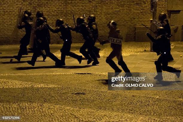 Spanish national police officers charge during a protest following the death of a street vendor at Lavapies district in Madrid on March 15, 2018....