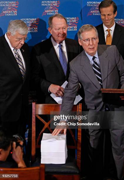 Senate Minority Leader Mitch McConnell points to a copy of the Senate version of health care reform legislation during a news conference with Sen....