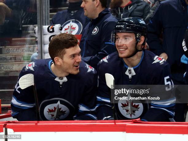 Jack Roslovic and Marko Dano of the Winnipeg Jets share a laugh at the bench prior to puck drop against the Chicago Blackhawks at the Bell MTS Place...