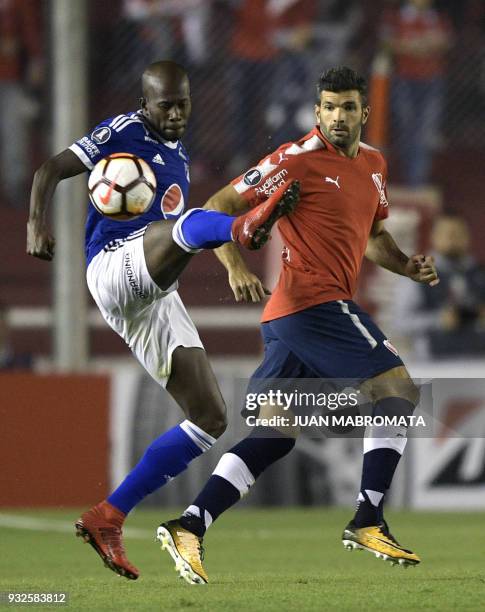 Colombia's Millonarios midfielder Jair Palacios vies for the ball with Argentina's Independiente forward Emmanuel Gigliotti during their Copa...