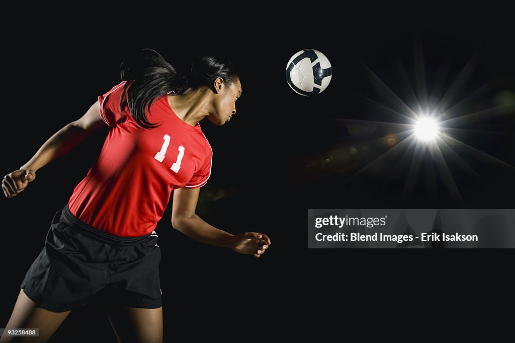 Soccer ball above mixed race soccer player