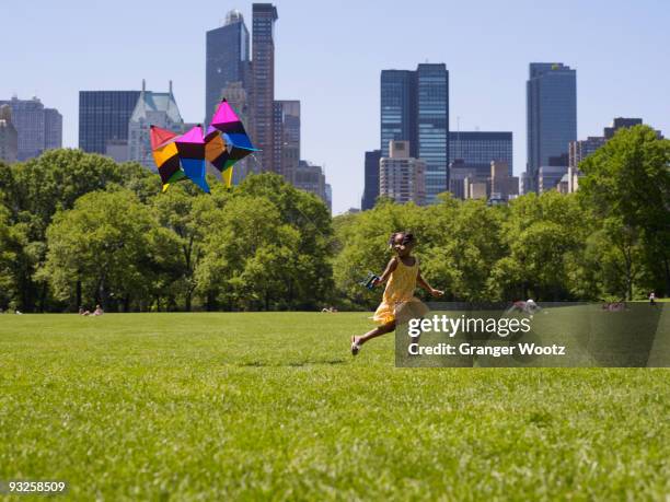 african girl flying kite in park - central park manhattan fotografías e imágenes de stock