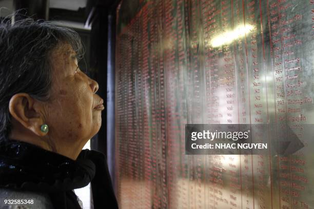 In this picture taken on March 15 local resident Truong Thi Hong looks at the names of relatives killed during the My Lai massacre at the war...