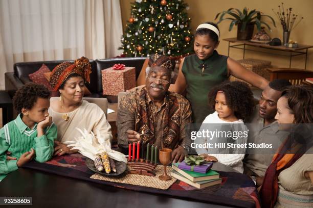 multi-generation family lighting kwanzaa candles - kwanzaa celebration stock pictures, royalty-free photos & images