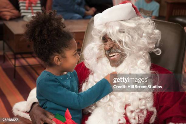 girl pulling on santa's beard - naughty santa stock pictures, royalty-free photos & images