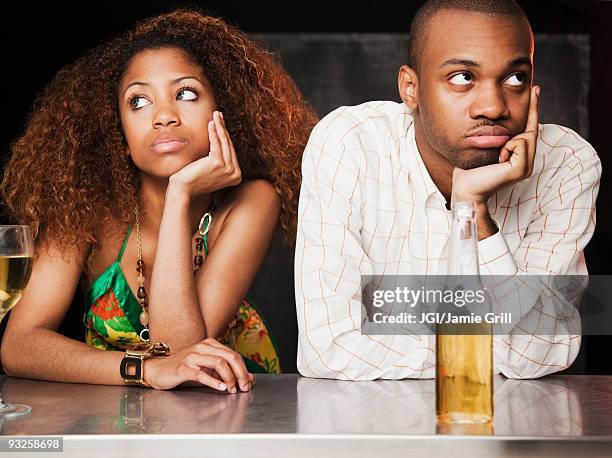 couple sitting at bar and looking irritated - bored girlfriend stock pictures, royalty-free photos & images