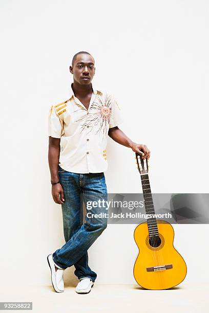 african man leaning on guitar - acoustic guitar white background stock pictures, royalty-free photos & images