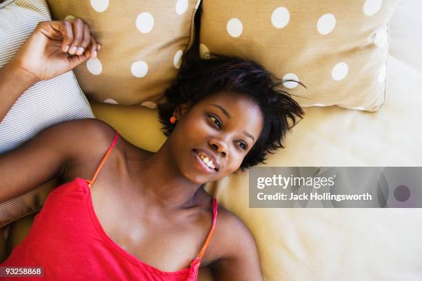 african woman laying on bed - lying on back stock pictures, royalty-free photos & images