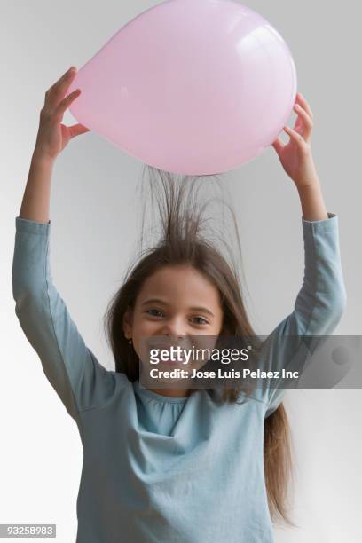 hispanic girl creating static in hair with balloon - child discovering science stock pictures, royalty-free photos & images