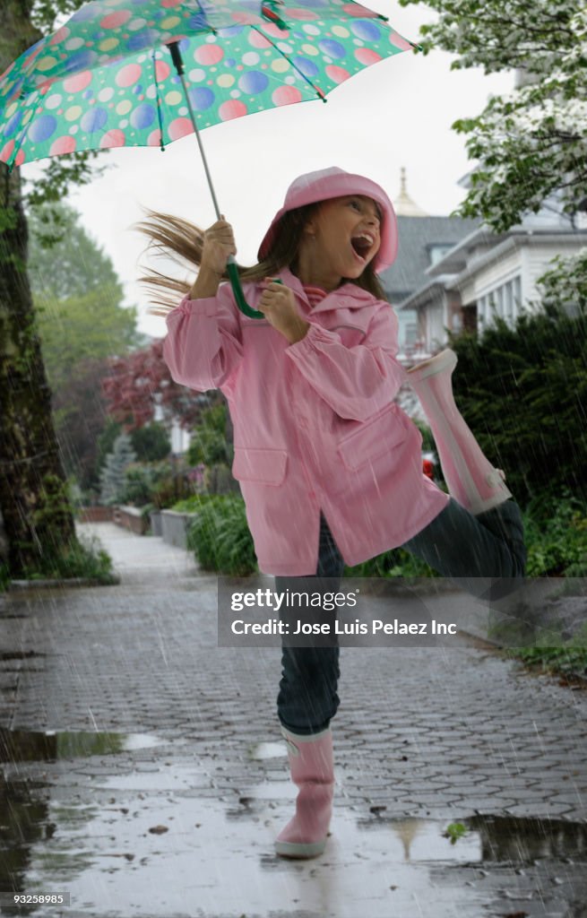 Hispanic girl playing in rain