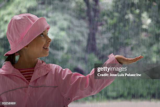 hispanic girl holding hand out in rain - caught in rain stock pictures, royalty-free photos & images