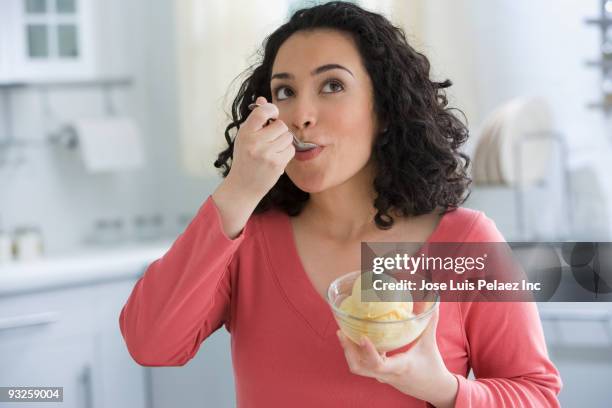 hispanic woman eating ice cream - eating icecream stock pictures, royalty-free photos & images