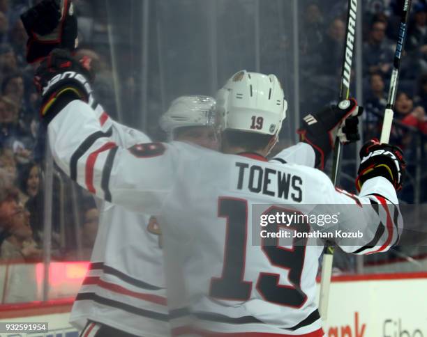 Jonathan Toews and Brandon Saad of the Chicago Blackhawks celebrate a first period goal against the Winnipeg Jets at the Bell MTS Place on March 15,...