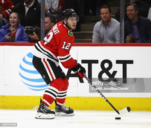 Alex DeBrincat of the Chicago Blackhawks controls the puck against the Calgary Flames at the United Center on February 6 2018 in Chicago, Illinois....