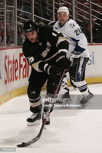 Zenon Konopka of the Tampa Bay Lighting chases the puck from behind against Mike Brown of the Anaheim Ducks during the game on November 19, 2009 at...