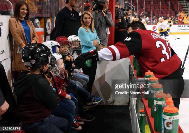 Zac Rinaldo of the Arizona Coyotes squirts water into the mouth of a youth hockey player prior to a game against the Nashville Predators Gila River...