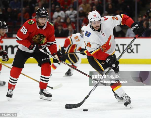 Travis Hamonic of the Calgary Flames looks to pass in front of Patrick Kane of the Chicago Blackhawks at the United Center on February 6 2018 in...