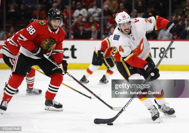 Travis Hamonic of the Calgary Flames looks to pass in front of Patrick Kane of the Chicago Blackhawks at the United Center on February 6 2018 in...