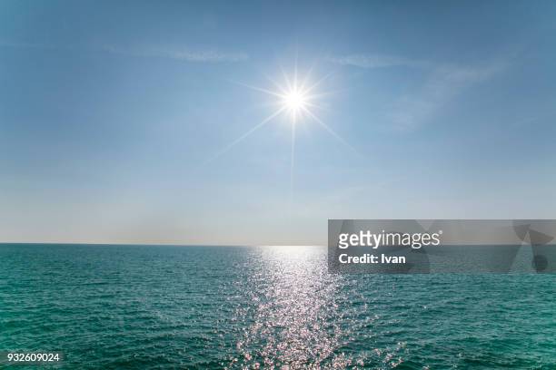 scenic view of sea against clear blue sky and sunlight - sonnenlicht stock-fotos und bilder