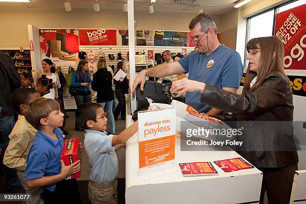Children lineup to give the cashier the coupons for their new shoes at Payless ShoeSource on November 20, 2009 in Cincinnati, Ohio.