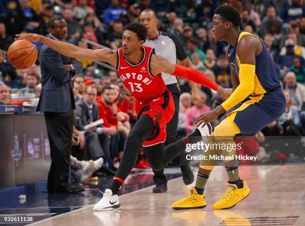 Malcolm Miller of the Toronto Raptors reaches for the ball as Victor Oladipo of the Indiana Pacers defends at Bankers Life Fieldhouse on March 15,...