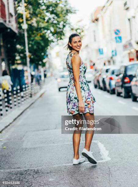 frau, die ein spaziergang in der stadt - woman looking over shoulder stock-fotos und bilder