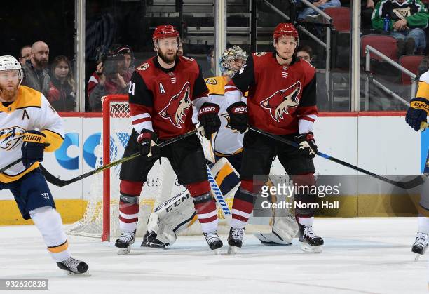 Derek Stepan and Richard Panik of the Arizona Coyotes position themselves in front of goalie Pekka Rinne of the Nashville Predators during the first...