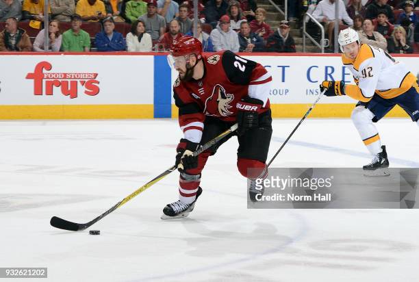 Derek Stepan of the Arizona Coyotes advances the puck up ice ahead of Ryan Johansen of the Nashville Predators during the first period at Gila River...