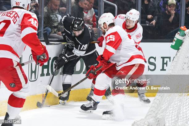 Alex Iafallo of the Los Angeles Kings battles for the puck against Mike Green and Danny DeKeyser of the Detroit Red Wings at STAPLES Center on March...