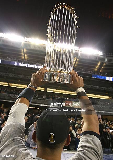 Alex Rodriguez of the New York Yankees celebrates with the World Series trophy after their 7-3 win against the Philadelphia Phillies in Game Six of...