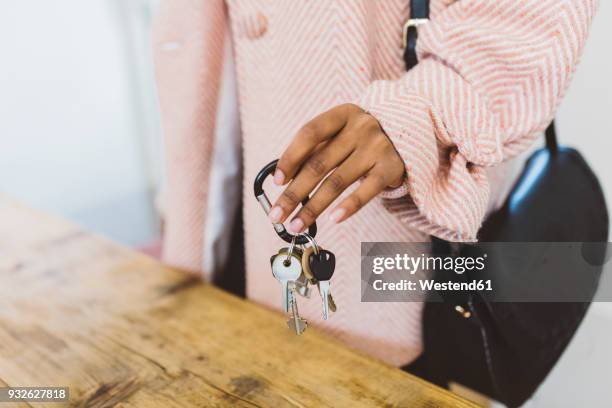 woman coming home, putting keys on table - trousseau de clés photos et images de collection