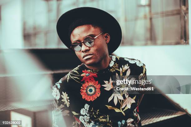 portrait of fashionable man wearing hat, sunglasses and black t-shirt with floral design - cool guy in hat stock pictures, royalty-free photos & images