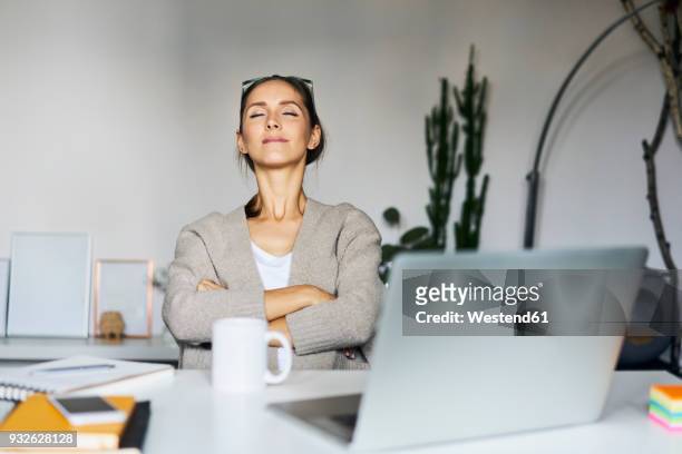 young woman at home with laptop on desk having a break - contento foto e immagini stock