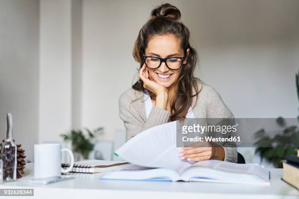 happy female student learning at home - reading glasses on table stock pictures, royalty-free photos & images